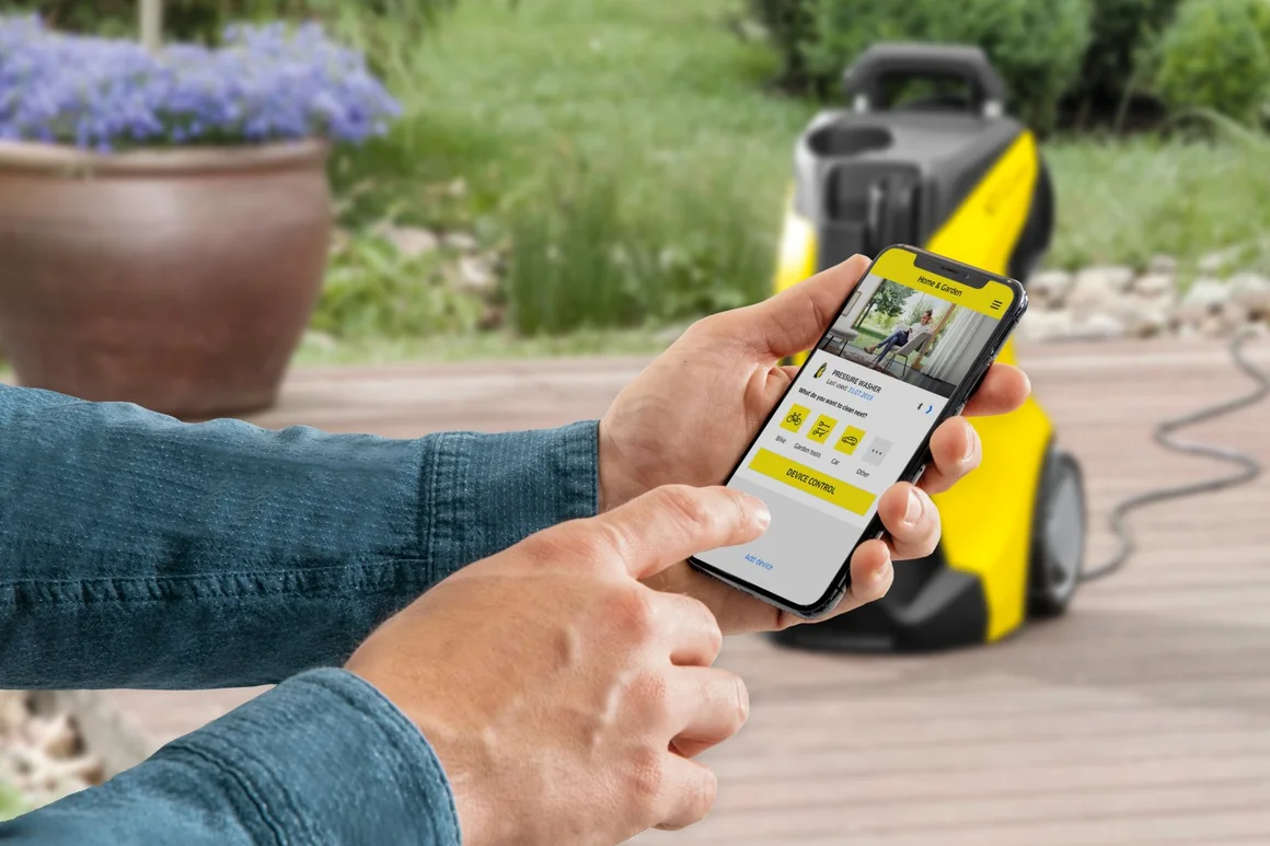 Person verwendet Smartphone um Hochdruckreiniger zu steuern